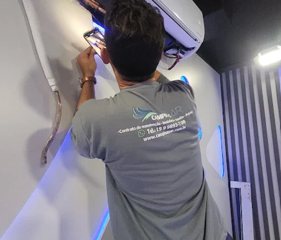 Técnico da Campinas AR higienizando ar condicionado split com equipamento profissional